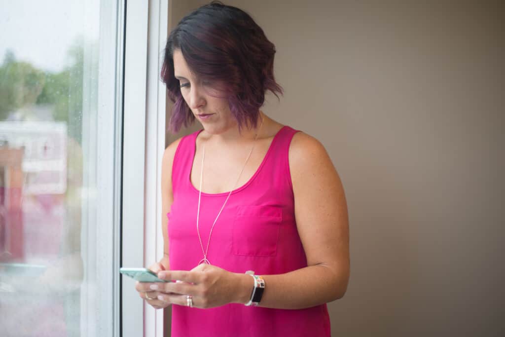 Woman by window looking at phone