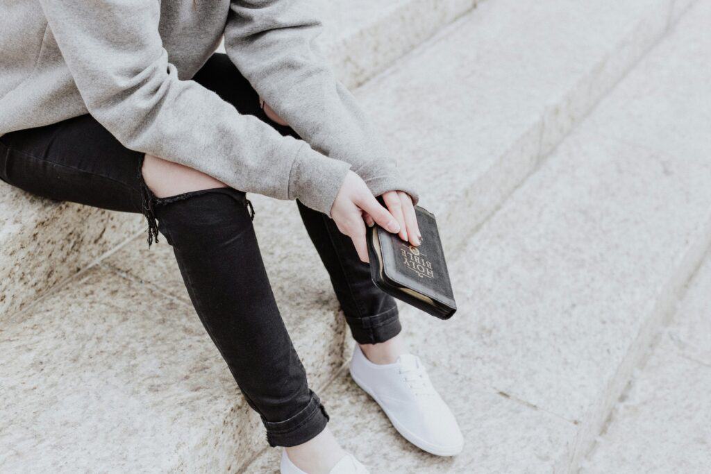 woman holding Bible closed in front of her